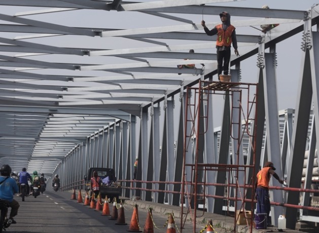 PERSIAPAN: Pekerja melakukan perawatan jembatan di jalur Mojokerto-Sidoarjo Desa Ngrame Kecamatan Pungging, Jumat (17/3) kemarin. (Sofan Kurniawan/JPRM)