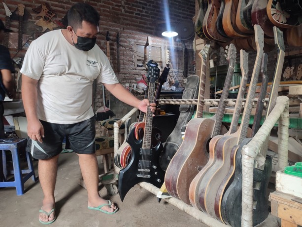 BERNILAI EKONOMIS: Frandy warga asal Pungging, Kabupaten Mojokerto mampu mengubah potongan kayu menjadi gitar elektrik. (Khudori Aliandu/JPRM)