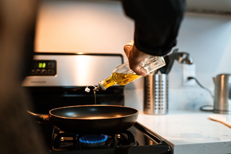Ilustrasi - seseorang menuangkan minyak goreng saat hendak memasak (ANTARA/Pexels)