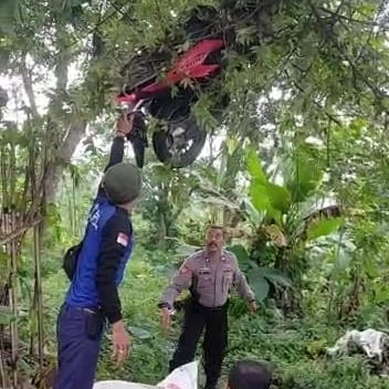 NYANGKUT: Tampak relawan dan polisi sedang berupaya menurunkan motor Honda Vario nopol W 4403 BZ yang tersangkut dahan pohon setinggi kurang lebih 2 meter, Minggu (30/4). (Yulianto Adi Nugroho/JPRM)