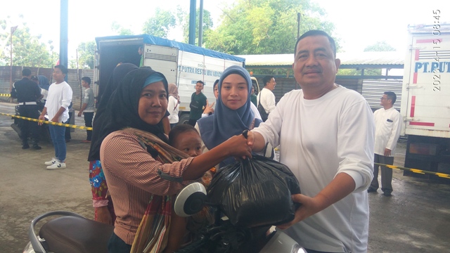 PEDULI: Tulus Widodo, Komisaris PT Putra Restu Ibu Abadi membagikan sembako kepada salah satu warga. (Dodik Rudiyanto/JPRM)