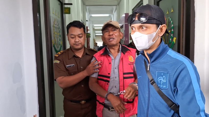 MENUJU TAHANAN: Kades Lolawang Sugiharto dengan mengenakan rompi merah dibawa menuju rutan Kejati Jatim dari Kejari Kabupaten Mojokerto usai ditetapkan sebagai tersangka korupsi, Kamis (13/4/2023). (Yulianto Adi Nugroho/JPRM)