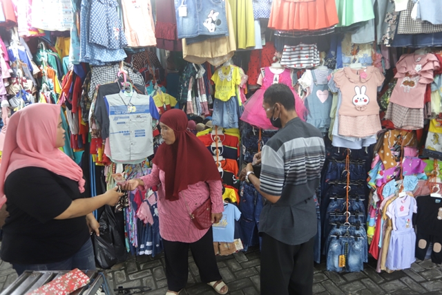 LEBIH DINI: Salah satu pembeli tengah memilih model busana baru yang akan digunakan ketika Idul Fitri nanti di Pasar Benpas, Kota Mojokerto, kemarin (4/4). (Sofan Kurniawan/JPRM)