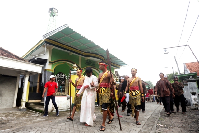 JALAN SALIB: Umat kristiani di Dawarblandong, Kabupaten Mojokerto melintasi depan musala ketika memperingati Jalan Salib dalam perayaan Jumat Agung, kemarin (7/4). (Sofan Kurniawan/JPRM)