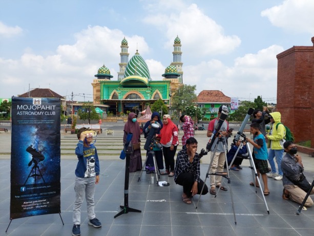 ANTUSIAS: Mojopahit Astronomi Club meneropong peristiwa gerhana matahari hibdrida bersama pengunjung Alun-Alun Kota Mojokerto, Kamis (20/4) lalu. (Indah Oceananda/JPRM)