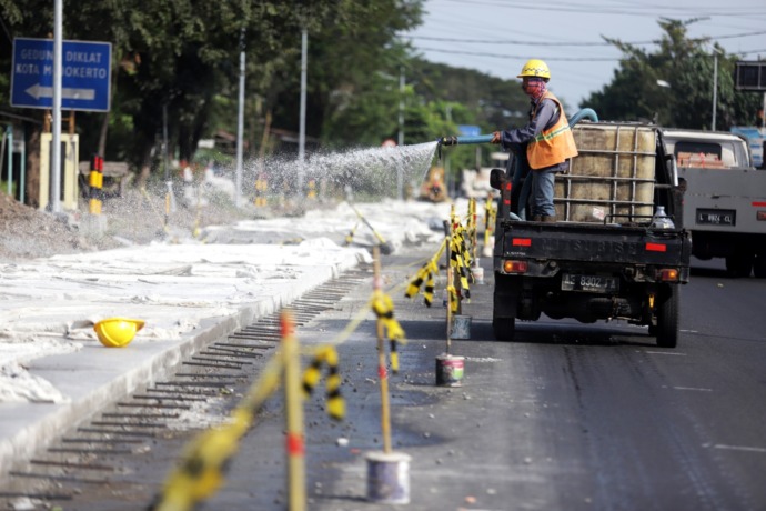 BERLAKU SATU JALUR: Proses pengecoran Jalan Bypass, Kota Mojokerto, dari simpang Sekarputih sampai perlintasan KA Gunung Gedangan, kemarin. (Sofan Kurniawan/JPRM)