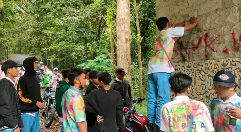 DISANKSI: Puluhan pelajar yang konvoi dan mencoreti gapura Tahura Raden Soerjo di Kecamatan Pacet dihukum menghapus cat, kemarin. (dok UPT Tahura R Soerjo for JPRM)