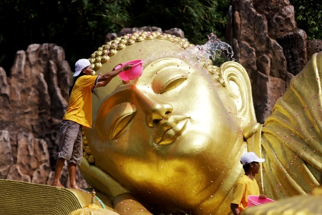 SAMBUT WAISAK: Petugas sedang membersihkan patung Buddha Tidur menggunakan air bunga di Maha Vihara Mojopahit, Desa Bejijong, Kecamatan Trowulan, Kabupaten Mojokerto, kemarin. (Sofan Kurniawan/JPRM)