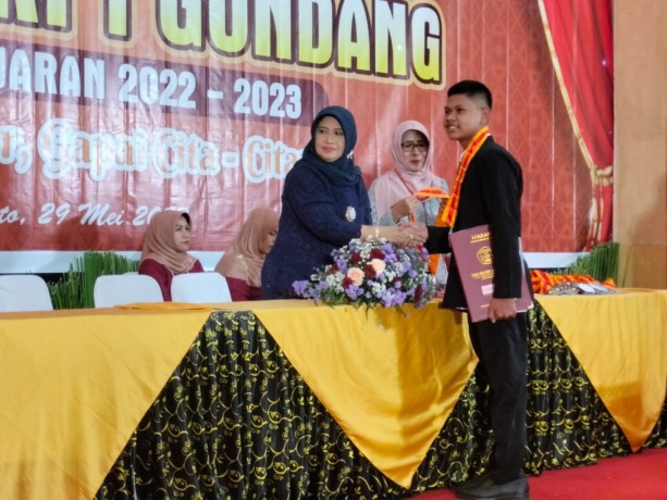 SUKSES: Kepala SMA Negeri 1 Gondang Nurul Wakhidah memberikan ucapan selamat kepada salah satu lulusan dalam kegiatan wisuda purnawidya. (Indah Oceananda/JPRM)