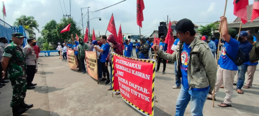 PROTES: Puluhan buruh pabrik PT Alu Aksara Pratama, Jalan Raya Perning, Kecamatan Jetis melakukan aksi turun jalan sebagai bentuk protes atas kesewenangan perusahaannya, beberapa waktu lalu. (Khudori Aliandu/JPRM)