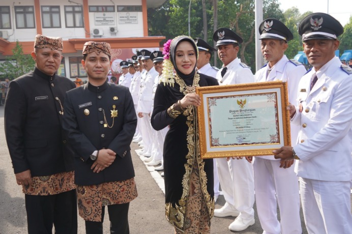 APRESIASI: Bupati Mojokerto Ikfina Fahmawati didampingi Wabup Muhammad Albarraa dan Sekda Teguh Gunarko menyerahkan penghargaan kepada para kades dan lurah yang berhasil membawa desanya lunas PBB P2, di puncak peringatan Hari Jadi Ke-730 Kabupaten Mojoker