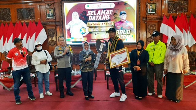 MEMBANGGAKAN: Wali Kota Ika Puspitasari menyerahkan piagam penghargaan dan menyematkan Duta Olahraga Kota Mojokerto kepada Bintang Akbar, atlet peraih medali emas SEA Games 2023 di Pendapa Sabha Kridatama, Rumah Rakyat, Senin (22/5). (Rizal Amrulloh/JPRM)