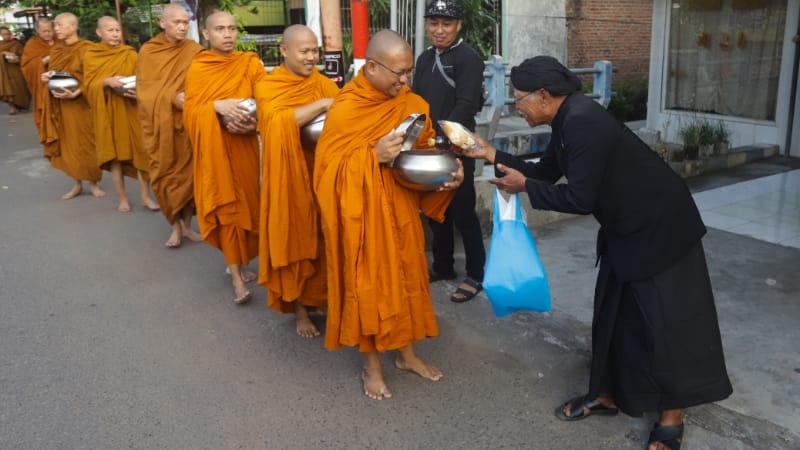WELAS ASIH: Para Biksu dan Biksuni menerima pemberian makanan dari masyarakat saat melaksanakan ritual Pindapatta jelang Waisak, Minggu (4/6) pagi.  (Sofan Kurniawan/JPRM)