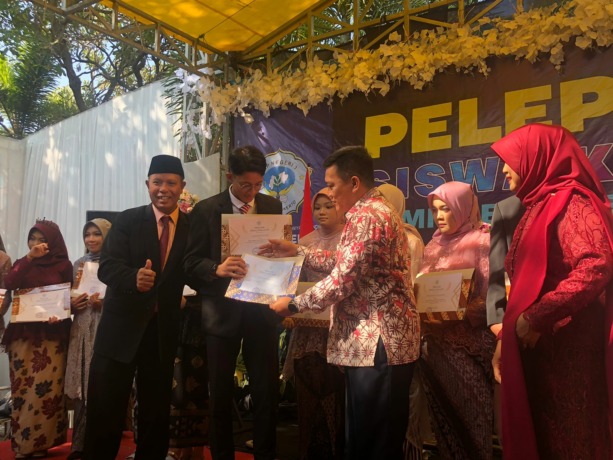 APRESIASI: Kepala Dikbud Kota Mojokerto Amin Wachid bersama Kepala SMPN 3 Kota Mojokerto Rejo memberikan penghargaan kepada salah satu murid berprestasi. (Indah Oceananda/JPRM)