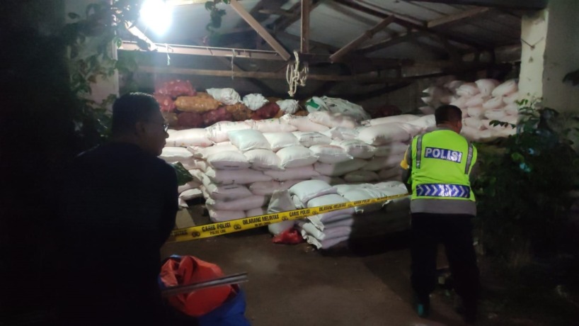 DISEGEL: Polisi memasang garis polisi di gudang penyimpanan pupuk bersubsidi di Dusun Balong Lombok, Desa Sumolawang, Kecamatan Puri, Kabupaten Mojokerto. (Adi Nugroho/JPRM)