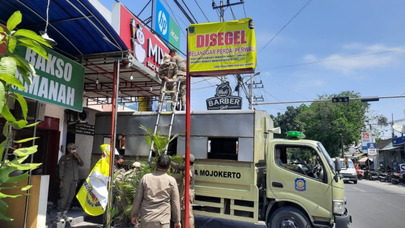 TAK BERIZIN: Reklame milik gerai minuman waralaba di Jalan Raya Ijen, Wates disegel petugas Satpol PP Kota Mojokerto, Selasa (30/5). (dok Satpol PP Kota Mojokerto for JPRM)