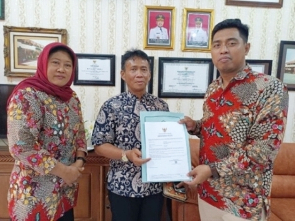 RESMI: Kepala SMPN 1 Gresik Beri Avita Prasetya bersama Humas Karyati menunjukkan sertifikat halal didampingi Andik Suyono selaku pejabat fungsional pengembang teknologi pembelajaran Dinas Pendidikan