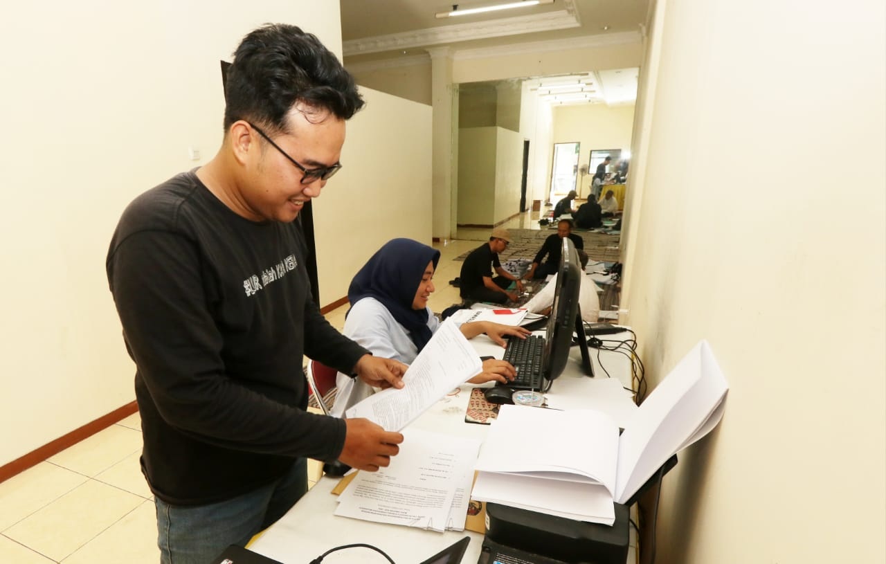 TERKENDALA : Staf Timsel Bawaslu Zona II saat memeriksa dokumen administrasi para peserta calon anggota Bawaslu Gresik periode 2023-2028.