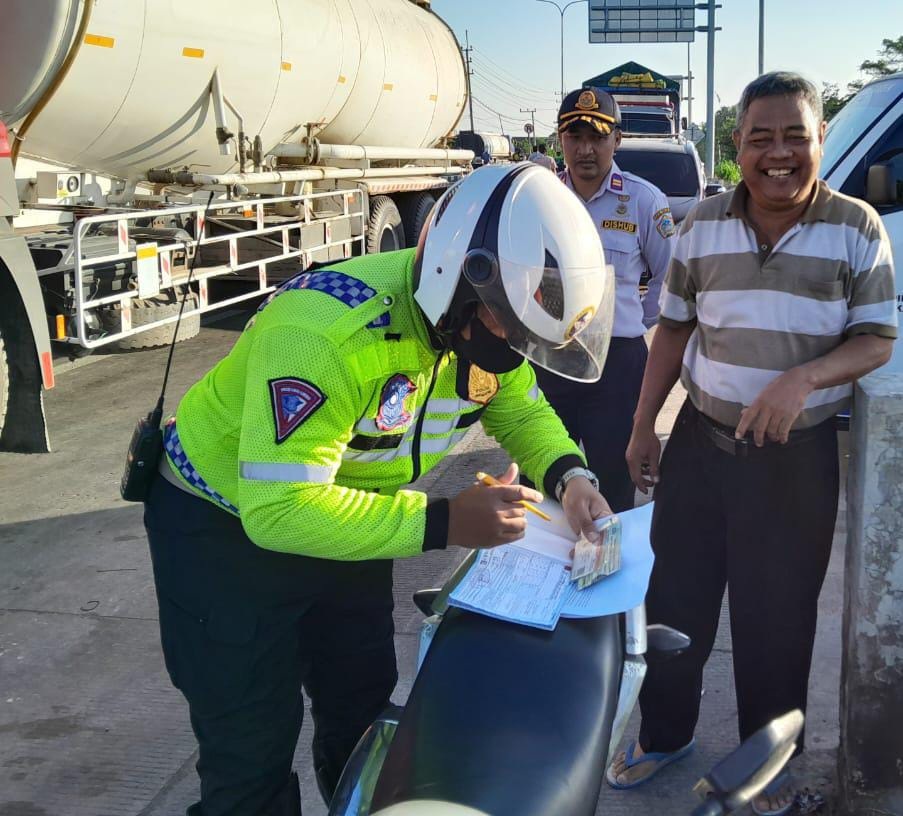 DITILANG : Anggota Satkantad saat menilang pengemudi truk yang langgar aturan jam operasional.