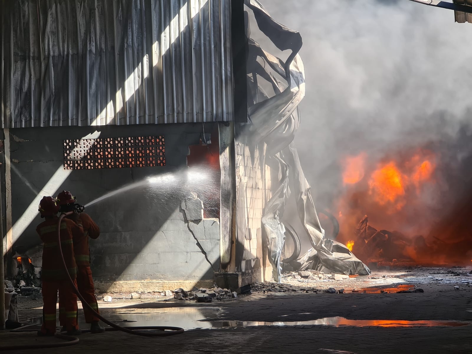 MEMBARA: Personil Damkarla Pemkab Gresik berjibaku memadamkan api yang membakar gudang PT Gunung Agung Sentosa Menganti.