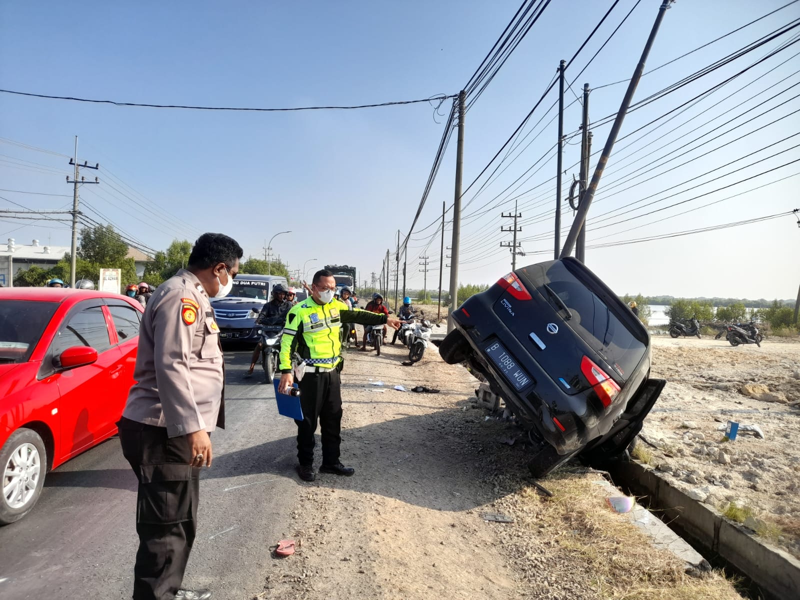 MASUK PARIT: Mobil minibus jenis Nissan Grand Livina dengan nopol B 1088 masuk parit usai menabrak tiga motor di Jalan Raya Desa Banyuwangi, Kecamatan Manyar.