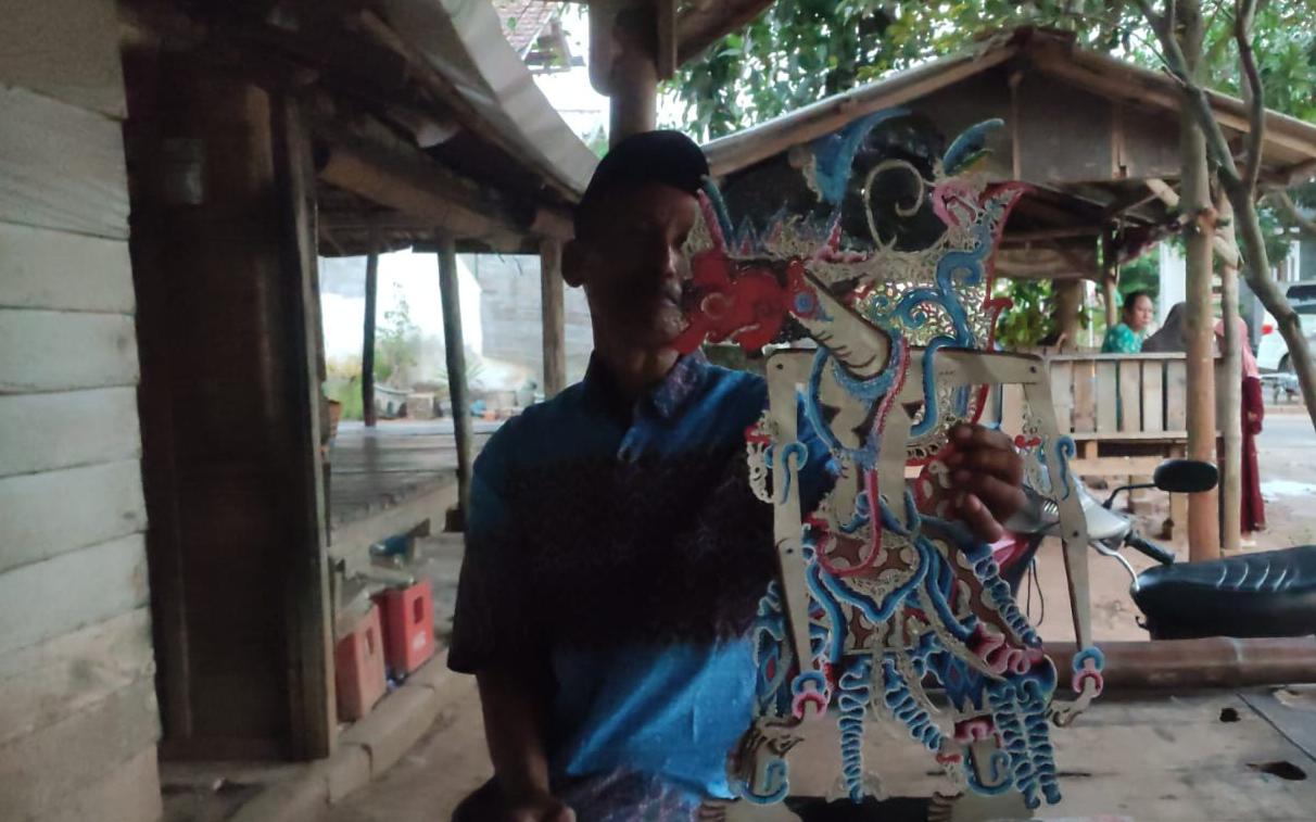 PENGRAJIN WAYANG: Suroto saat menunjukan hasil wayang kulit yang dibuatnya.
