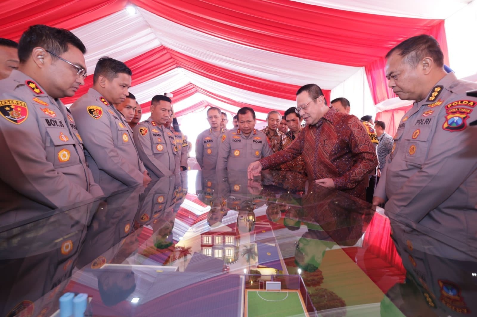 MELIHAT MAKET: Kapolres Gresik AKBP Panji Anom saat mendampingi Kapolda Jawa Timur Irjen Pol Toni Harmanto melihat maket pembangunan Polres Kawasan di area KEK JIIPE, Kecamatan Manyar.