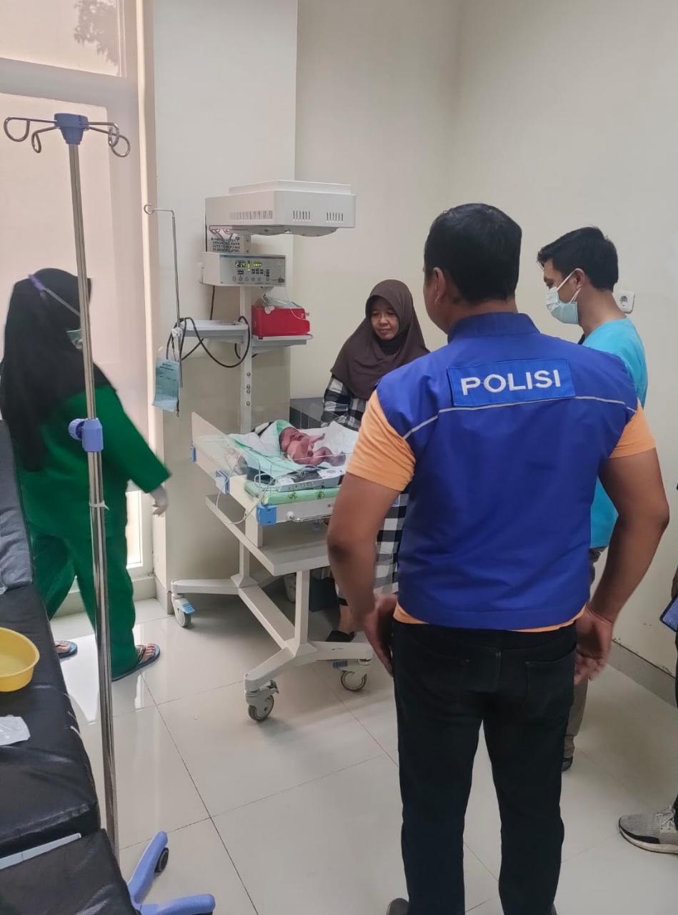MASIH PERAWATAN: Anggota Polisi saat mengantarkan bayi untuk mendapat perawatan medis.