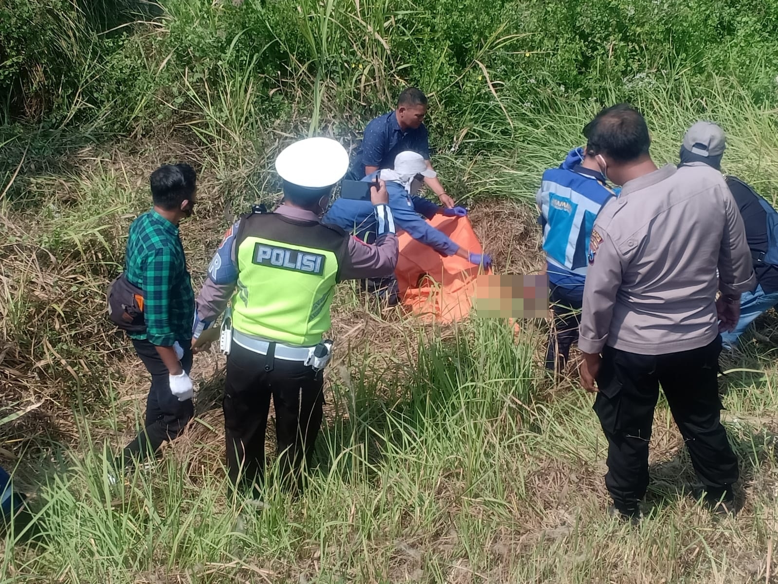 EVAKUASI:  Anggota Polisi saat melakukan olah TKP ditemukan mayat korban di bahu jalan Tol Sumo (Surabaya- Mojokerto) Km.732, Desa Sumput, Kecamatan Driyorejo.