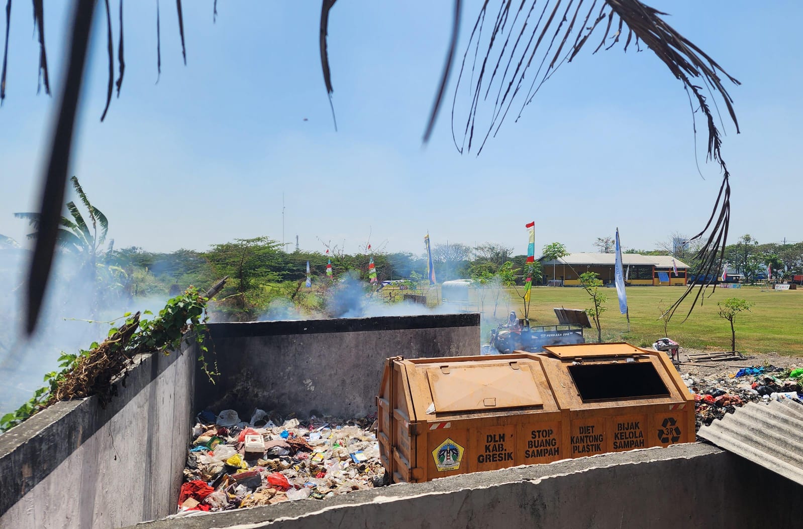 PEMBAKARAN: Petugas sedang membakar sampah di TPS yang menyebabkan asap tebal di kawasan perumahan. (itimewa/radar gresik)