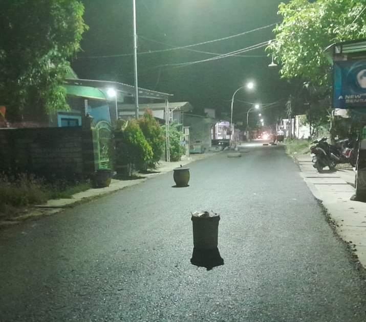 CEGAH KEBUT-KEBUTAN : Masyarakat yang tinggal disekitar Jalan tembusan Kendanyang Banjarsari menempatkan tong sampah dan ban bekas di tengah jalan mencegah pengendara kebut-kebutan. (FIRMAN/RADAR)