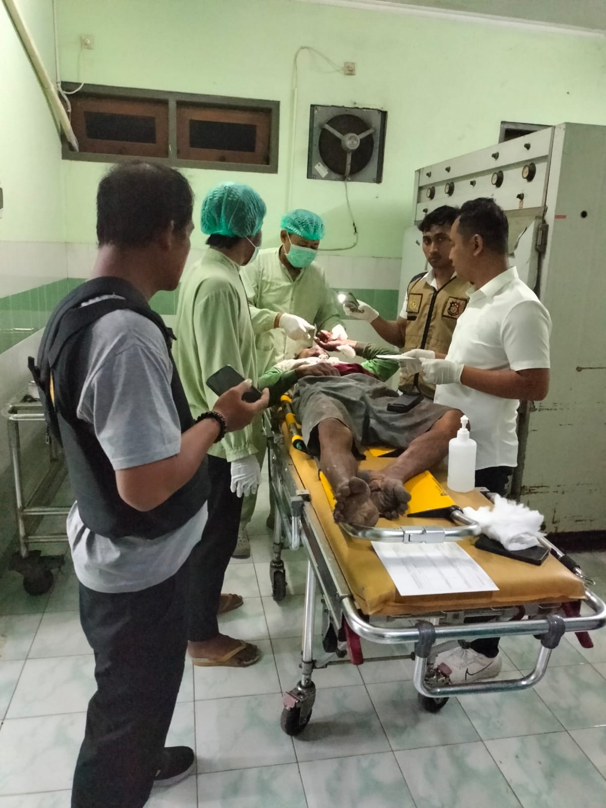 EVAKUASI: Anggota Polsek Dukun dibantu tim medis saat mengevakuasi mayat di dalam sebuah gubuk Sawah di Desa Sambogunung Kecamatan Dukun. (istimewa/Radar Gresik)