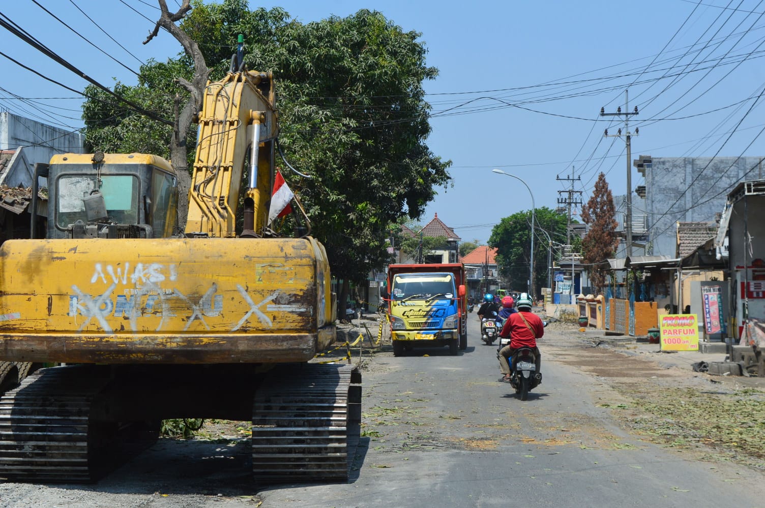 SUDAH DIMULAI: Alat berat terlihat melakukan penggalian tanah untuk pelebaran Jalan Cerme.