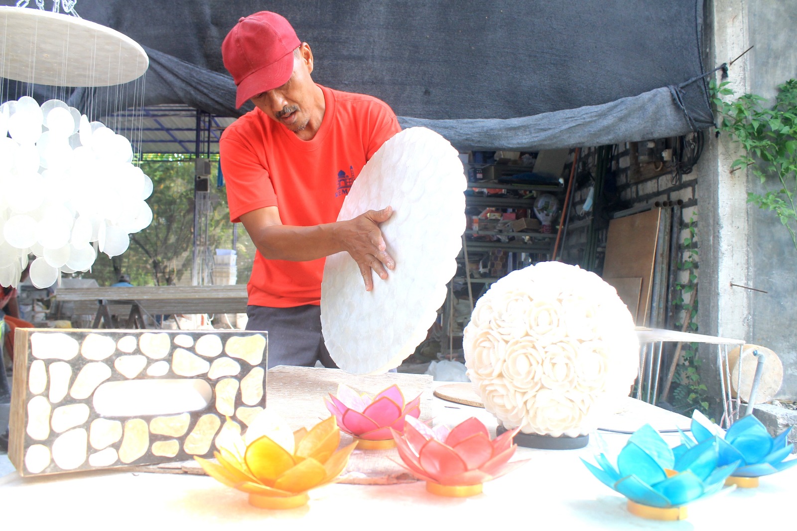 KREATIF: Seorang pekerja sedang membuat kerajina berbahan kulit kerang Simping di Desa Purwodadi, Kecamatan Sidayu.