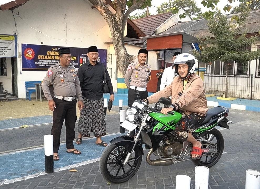 Foto 3: Kasat lantas Polres Gresik Akp Mulya Sugiharto menemani Gus Idam saat mencoba uji praktik SIM di halaman kantor Satlantas Polres Gresik.