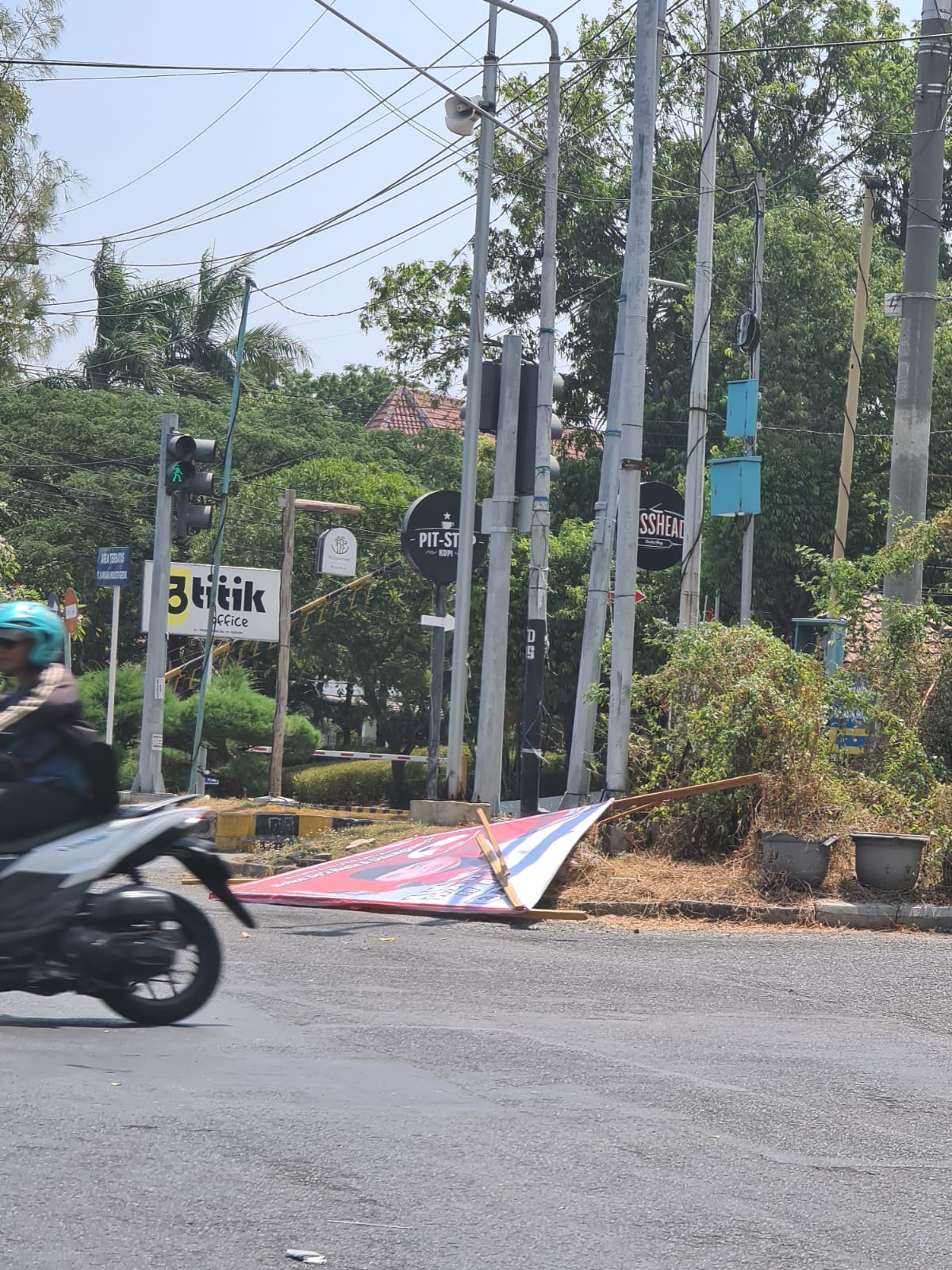 GANGGU MOBILITAS : Salah satu baliho yang ambruk akibat tersapu angin di Jalan Tri Dharma mengakibatkan arus lalu lintas terganggu.  &nbsp;