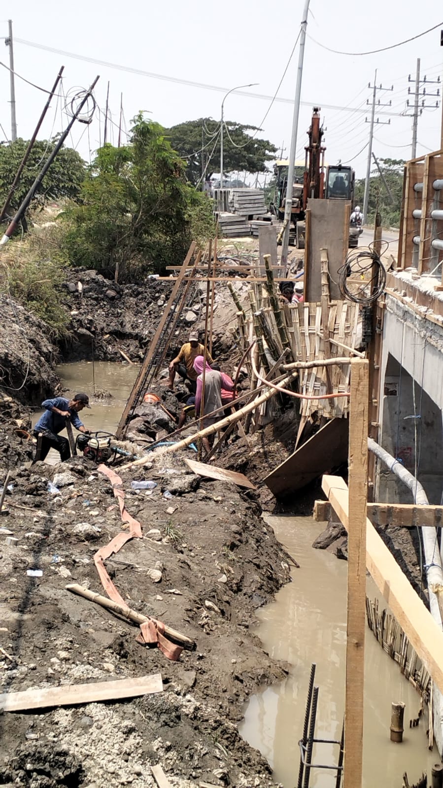 Kembali Mengalir : Perbaikan pipa PDAM yang pecah akibat proyek pelebaran jembatan Padeg selesai pada Minggu Sore.