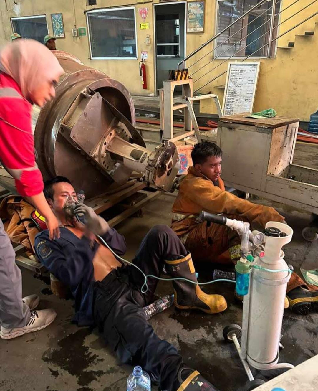 KEWALAHAN : Personil Damkarla Pemkab Gresik mendapatkan bantuan pernafasan oksigen dari tim medis.