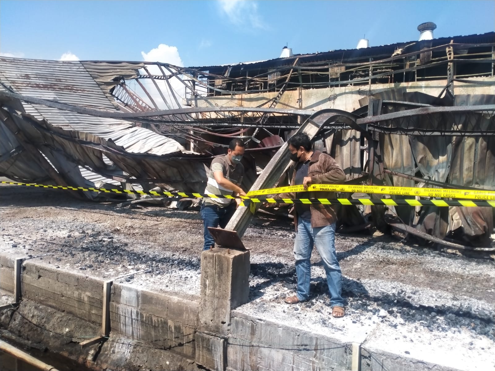 POLICE LINE: Anggota Satreskrim Polres Gresik memasang police line di PT Nankai Indonesia di Jalan Mayjend Sungkono No 23 Kebomas, Selasa (17/10).