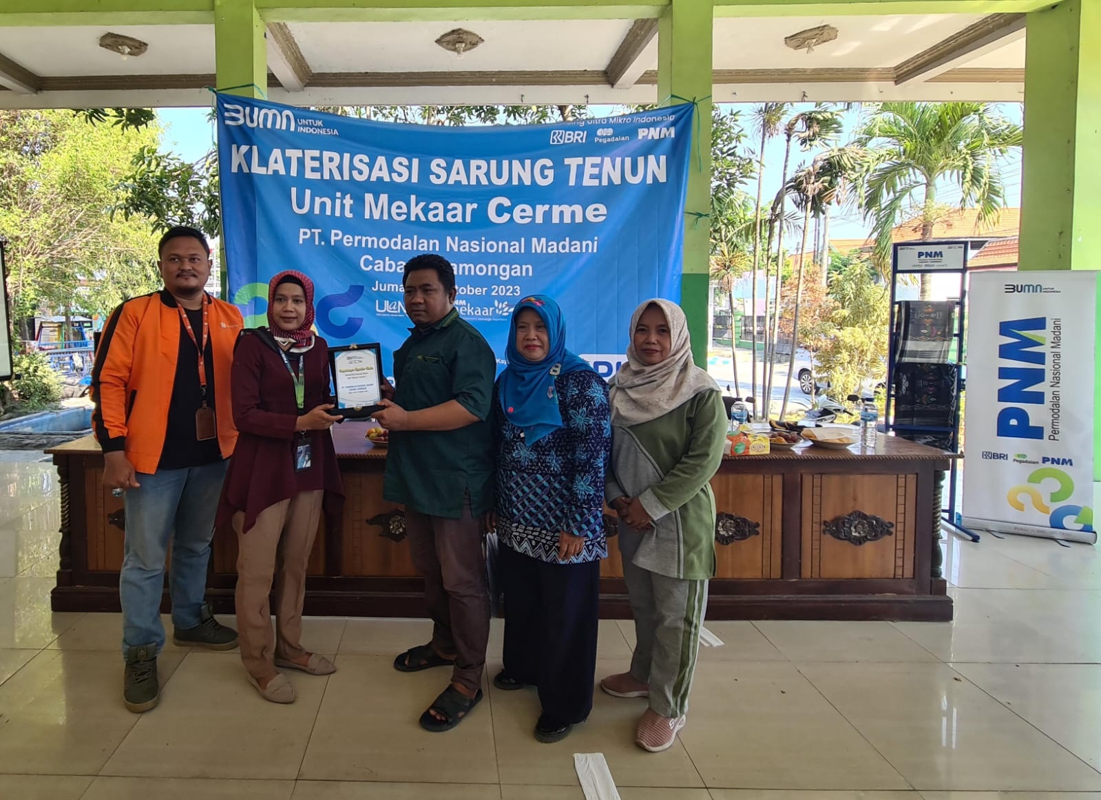 PERKUAT EKONOMI: Manager Pengawasan dan Monitoring PNM Mekaar Lamongan, Ariska Yunies Lisdyana memberikan penghargaan kepada Kepala Desa Wedani, Hadi Sanjaya didampingi Sekretaris Kecamatan Cerme,