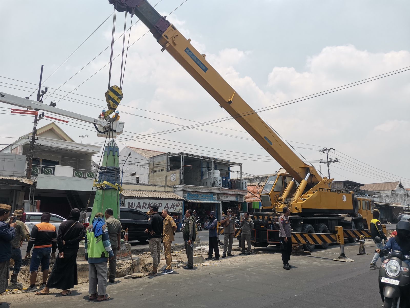KEMBALI DIPASANG: Alat berat terlihat memasang Tugu Manyar yang sebelumnya sempat diambil saat proses pembangunan jalan.