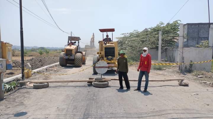 OPTIMISTISME: Petugas menyelesaikan proyek jalan Banjarsari ke Prambangan, Gresik