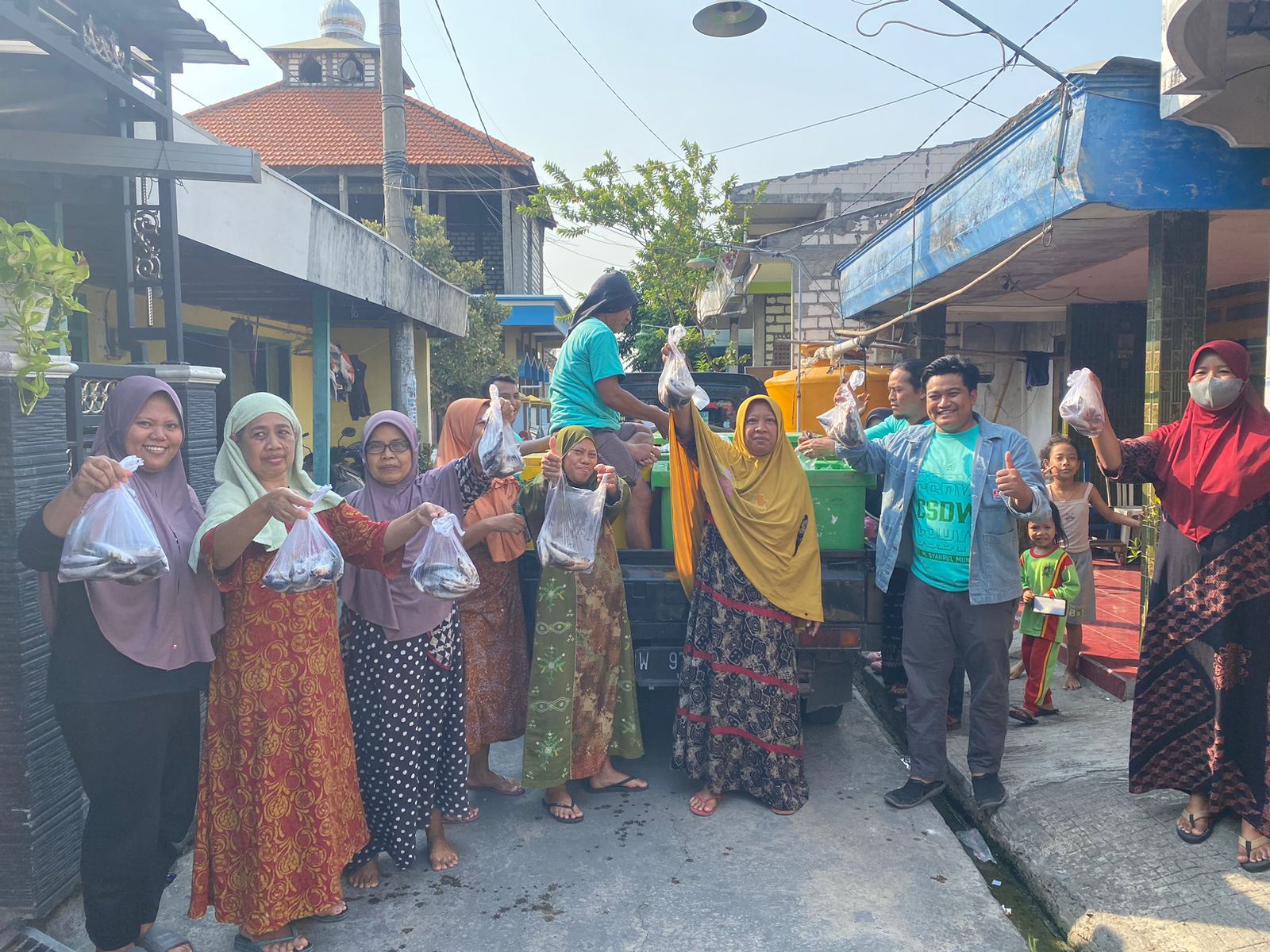 BAGI-BAGI: Ketua Fraksi PKB DPRD Gresik Syahrul Munir saat membagikan ratusan bungkus ikan segar kepada masyarakat Tanggulrejo.