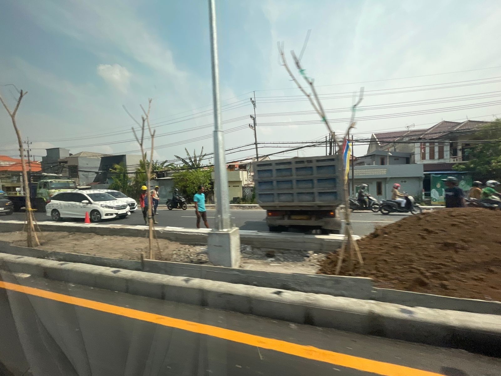 SUDAH TUNTAS: Para pekerja saat menyelesaikan pembangunan median jalan.