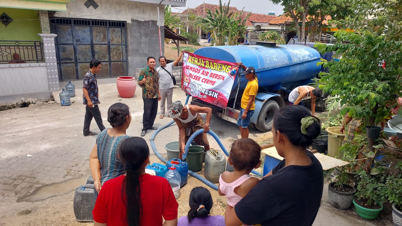 DROPPING AIR: Kapolsek Cerme Andik Asworo meninjau langsung pemberian air bersih kepada warga di beberapa desa diwilayah Kecamatan Cerme.