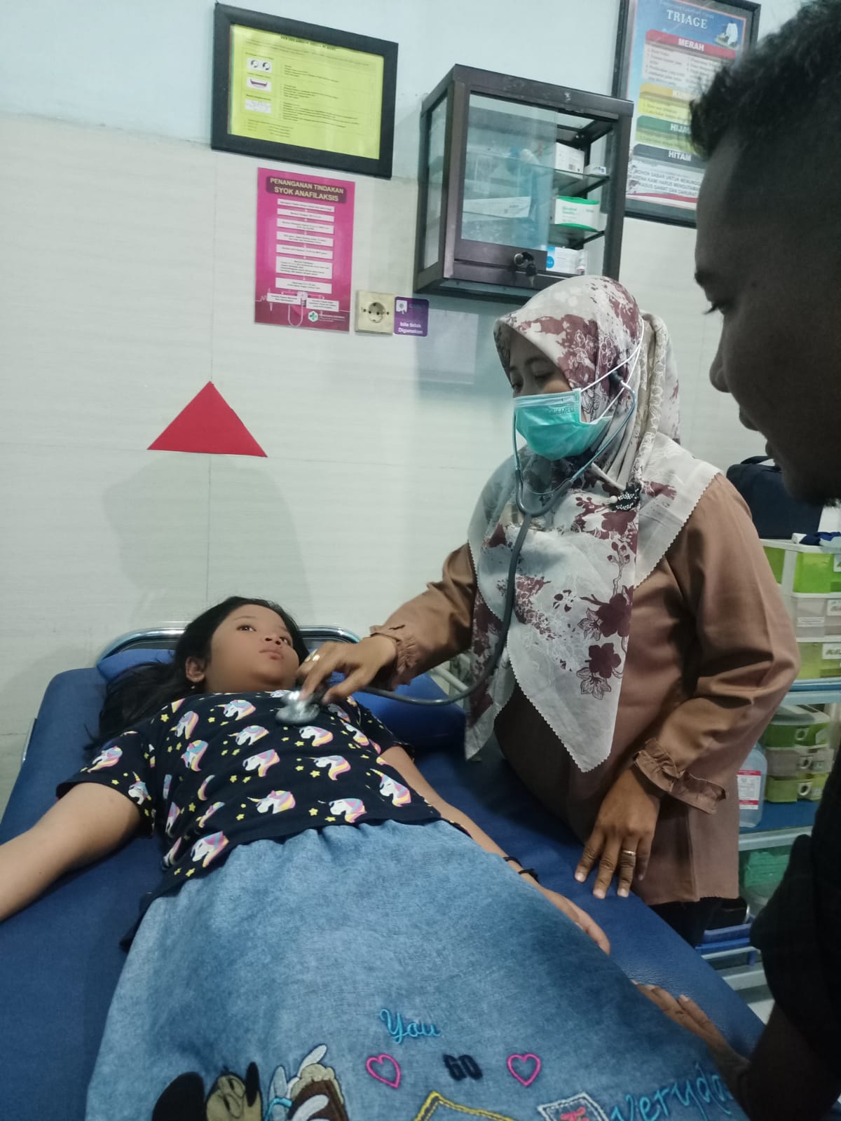 LAYANAN CEPAT: Hendra Kartika Yudha menemani putrinya Najma Ayucha saat dirujuk ke IGD Puskemas Kebomas, Kabupaten Gresik, Rabu (8/11/2023)