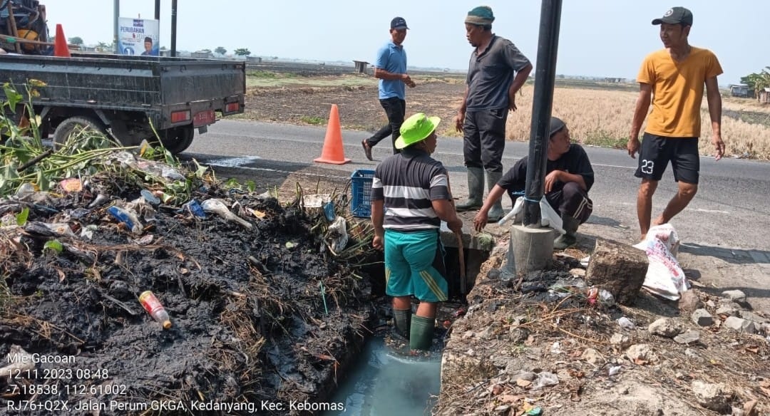 BERSIH-BERSIH: Petugas DCKPKP Gresik saat membersihkan saluran air di wilayah kota.