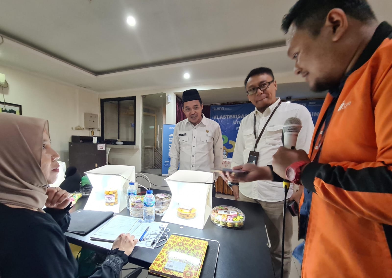 Dorong UMKM Naik Kelas : Camat Kebomas, M Jusuf Ansori bersama Pimpinan PT Permodalan Nasional Madani (PNM) Cabang Lamongan menyaksikan narasumber program klasterisasi pelatihan foto produk.