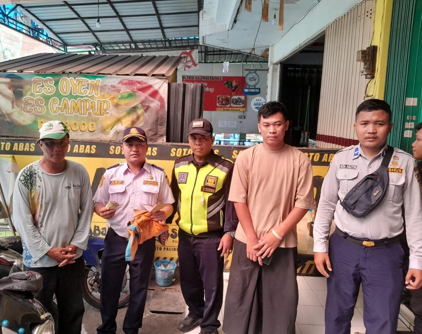 TEGAS: Kepala Seksi Prasarana dan Sarana Perparkiran Dishub Gresik, Masyhur Arief (dua dari kiri) melepas baju oknum jukir di GKB yang telah mengancam salah satu pemilik usaha.
