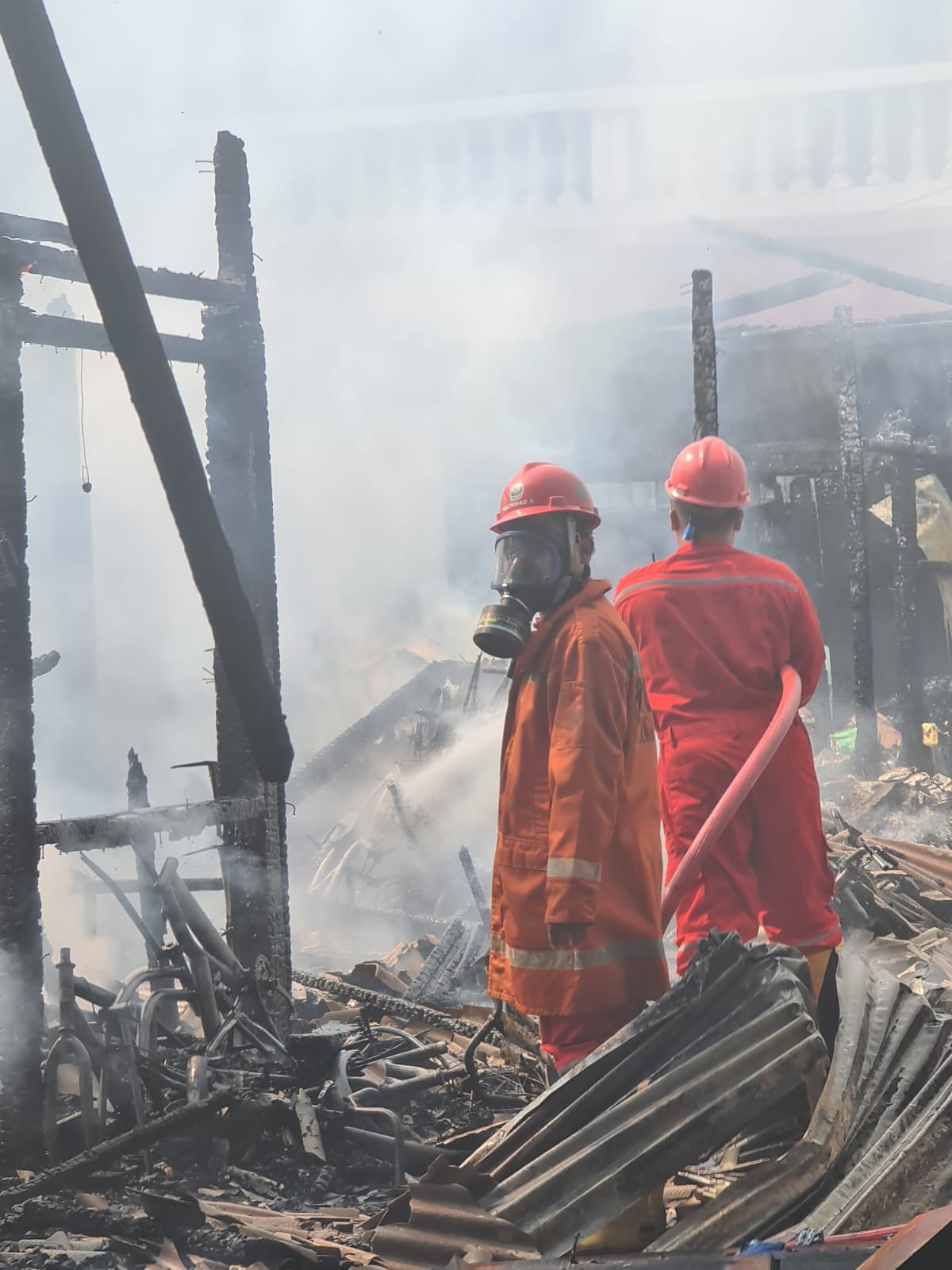 BERJIBAKU: Petugas Damkarla Gresik berjuang untuk memadamkan apik karena kebakaran di Pasar Gresik.